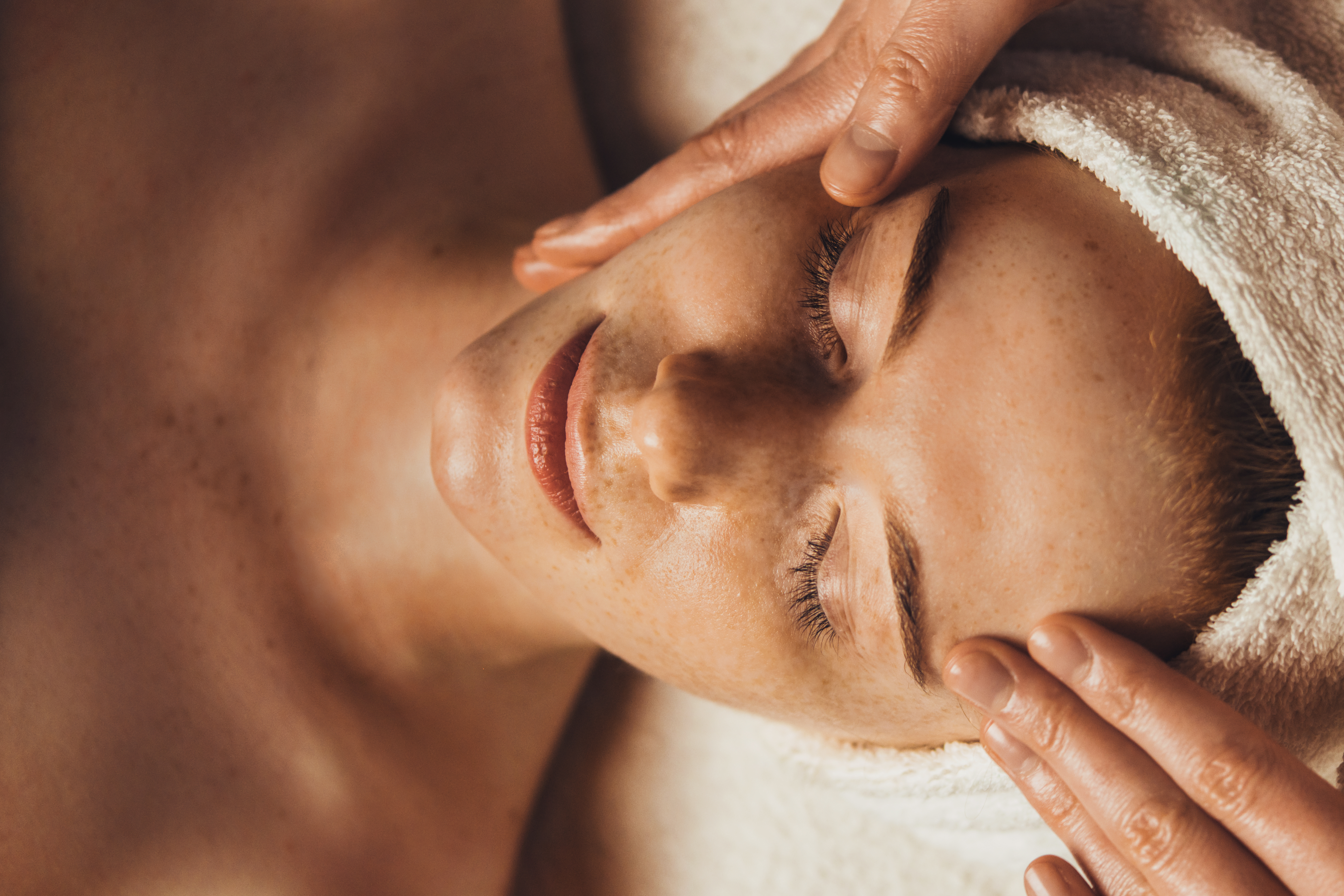 Caucasian freckled woman having a facial massage beauty treatment. Natural woman beauty, skincare. Beauty treatment. Beauty portrait. Healthy lifestyle.
